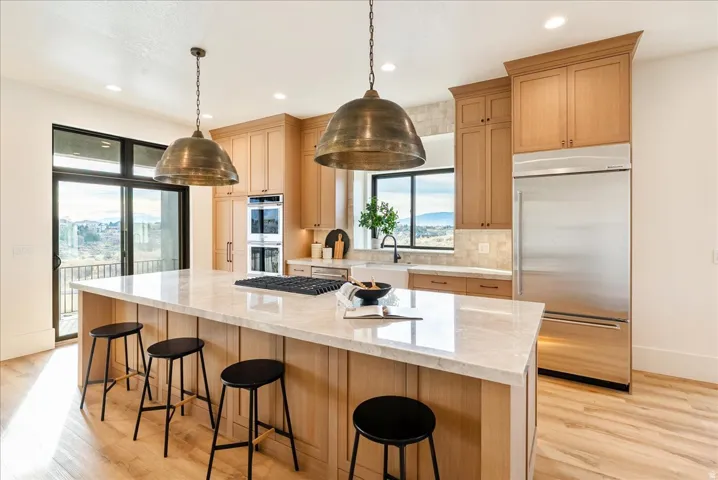 Kitchen with stainless steel appliances, a breakfast bar, and light wood finish cabinets