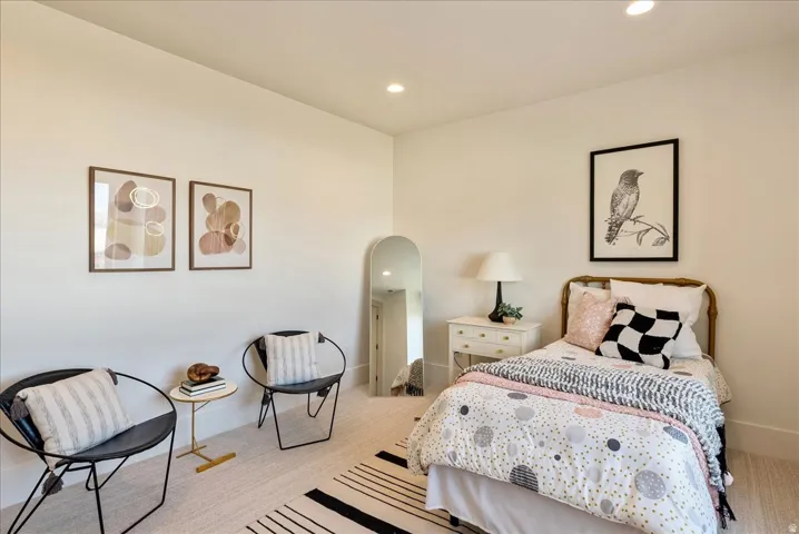 Bedroom featuring recessed lighting, light colored carpet, and arched walkways