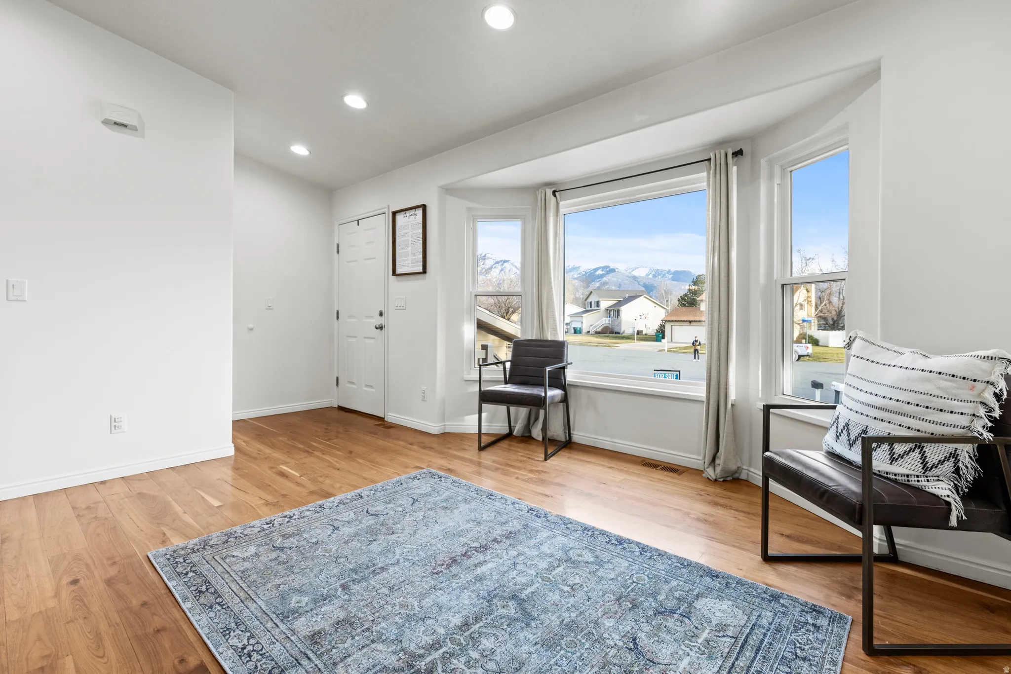 Foyer entrance with a mountain view, light wood-style floors, and recessed lighting