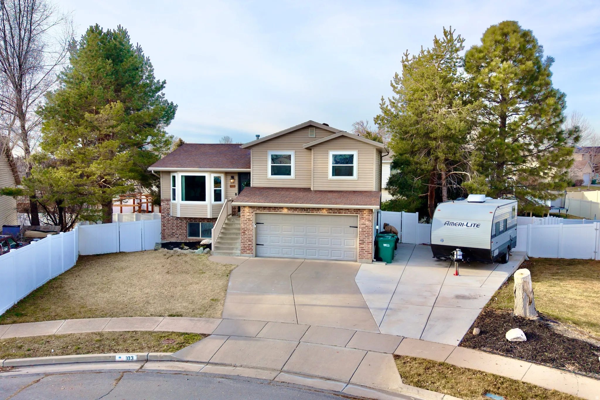 View of front of property with concrete driveway, an attached garage, and brick siding