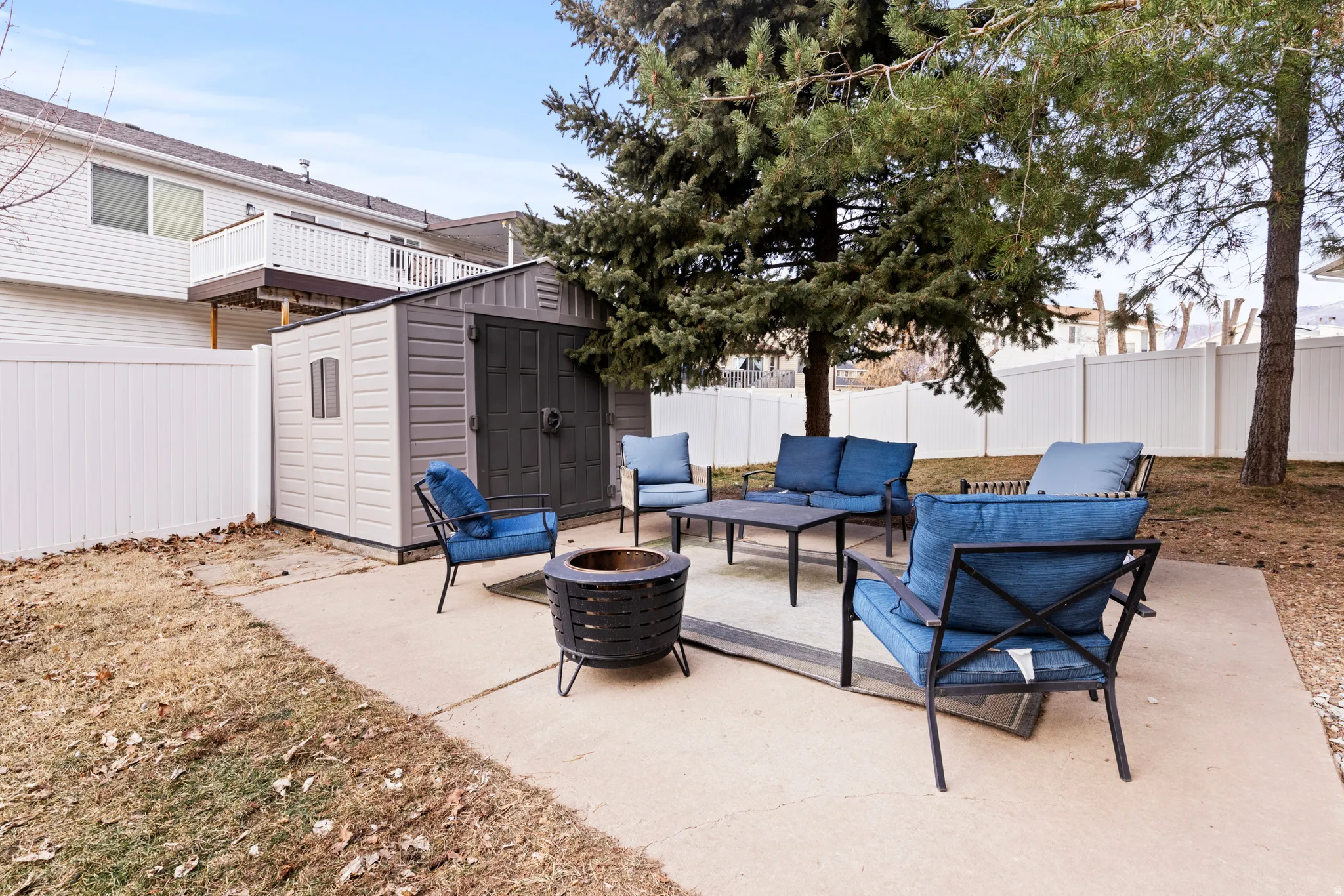 Fenced backyard featuring an outdoor living space with a fire pit, a shed, and a patio area