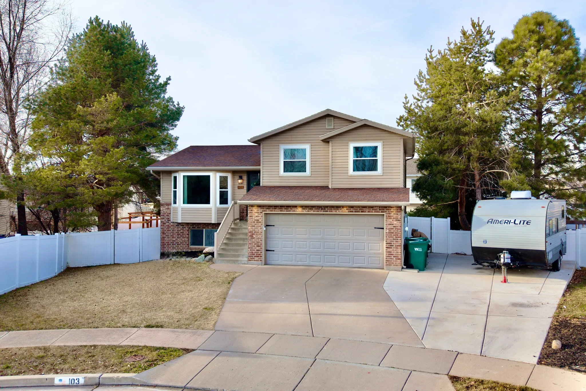 View of front facade with brick siding, driveway, an attached garage, and a shingled roof