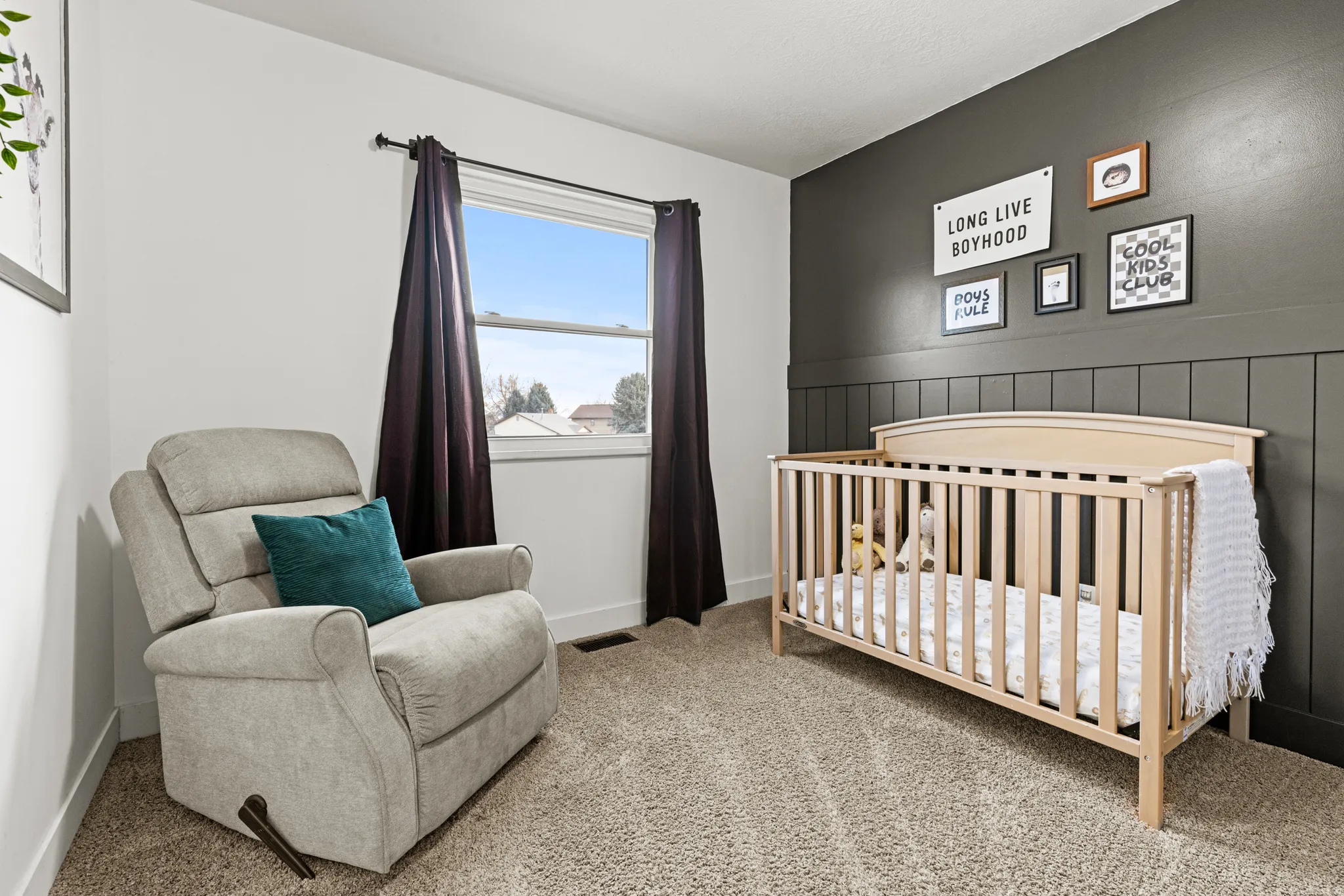 Bedroom featuring a crib and light colored carpet