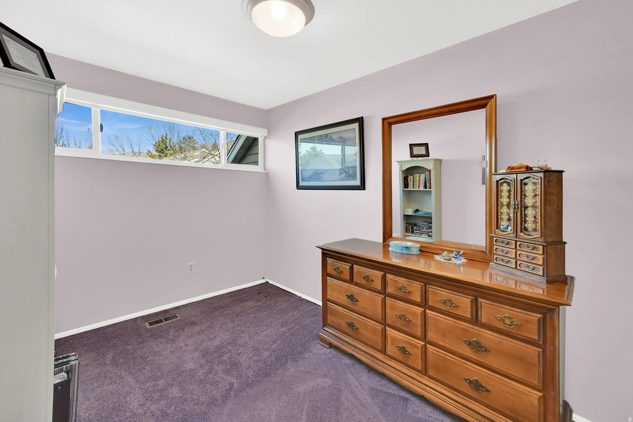 Bedroom with dark colored carpet and baseboards