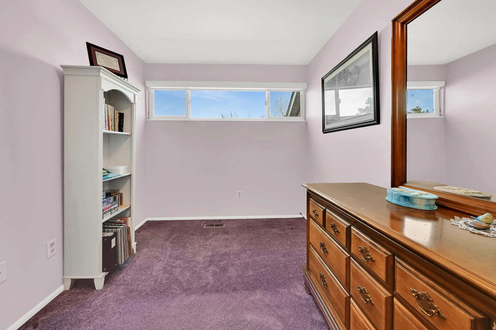 Hallway featuring dark colored carpet and baseboards
