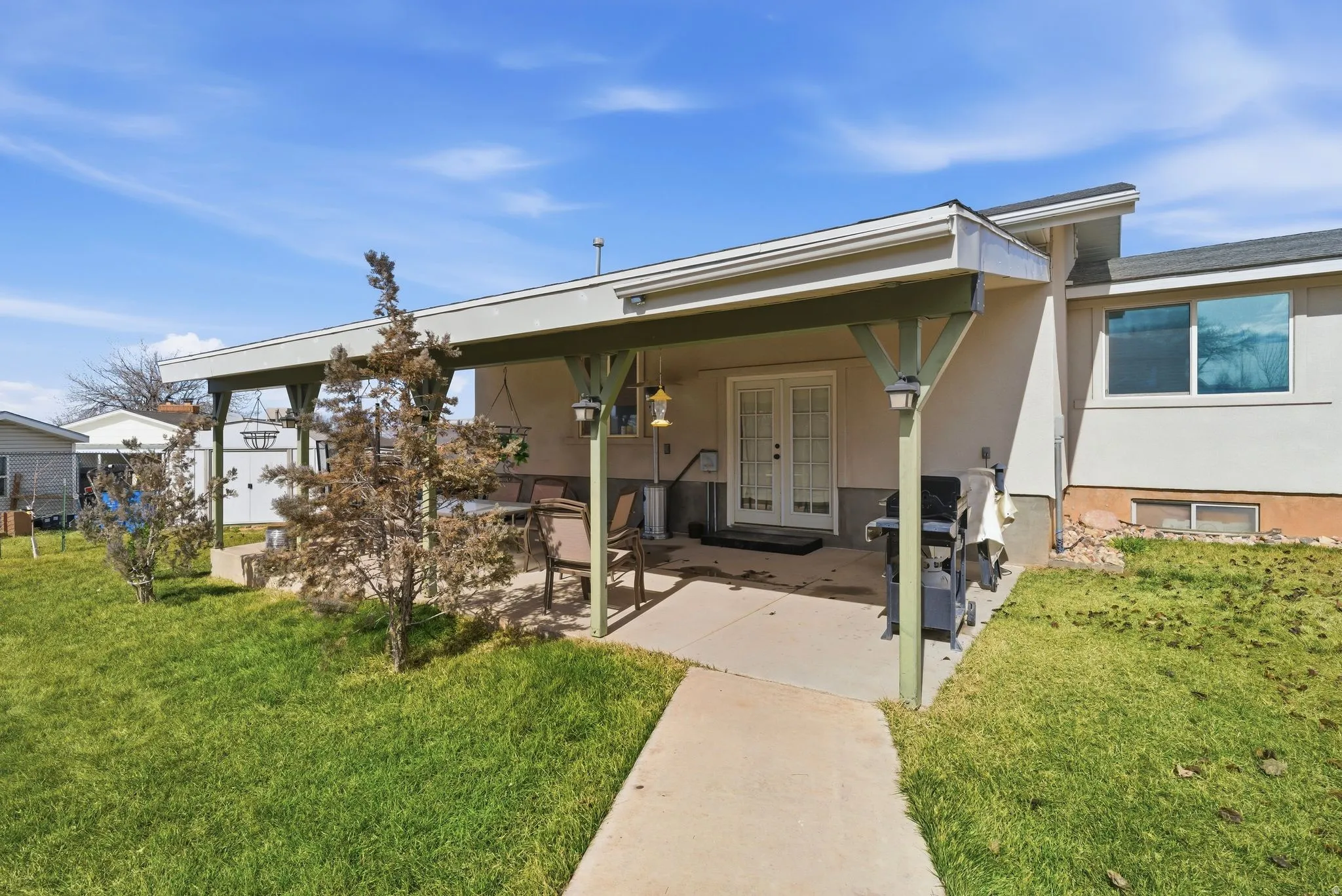 View of front of property featuring a patio, french doors, a front yard, and stucco siding