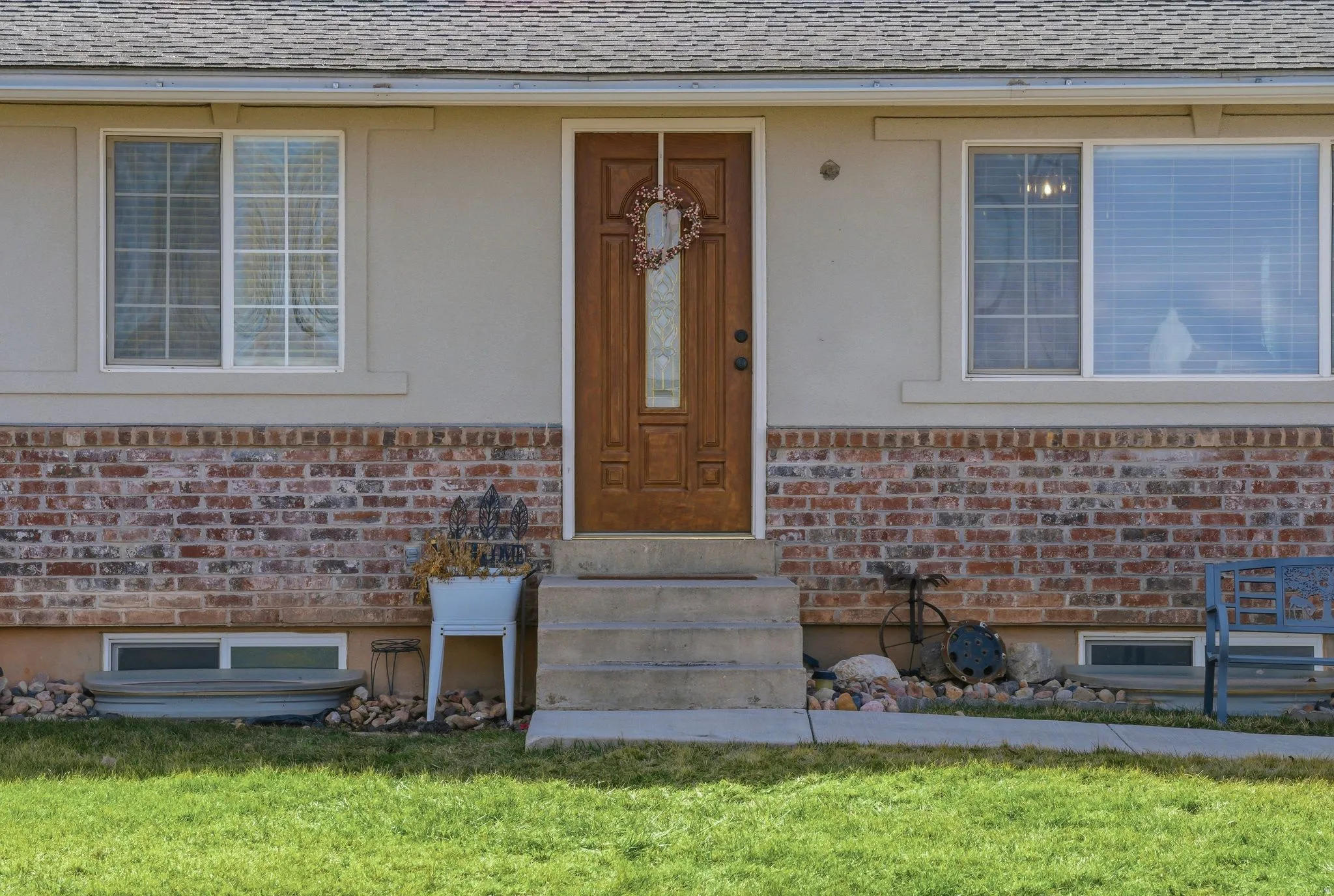 Entrance to property featuring brick siding, roof with shingles, and a lawn