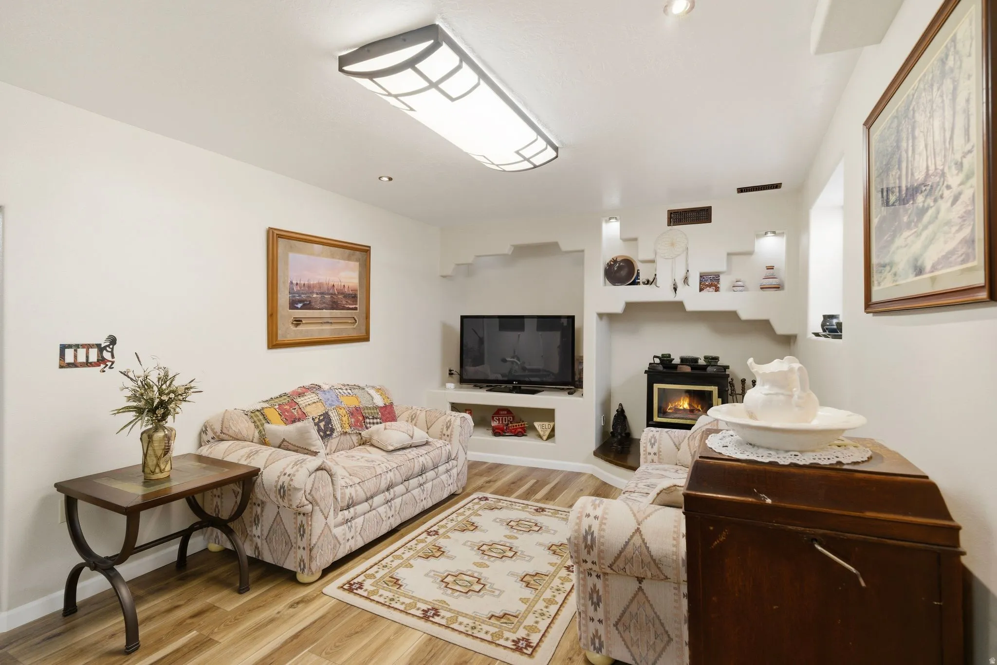 Living room featuring light wood finished floors and a glass covered fireplace