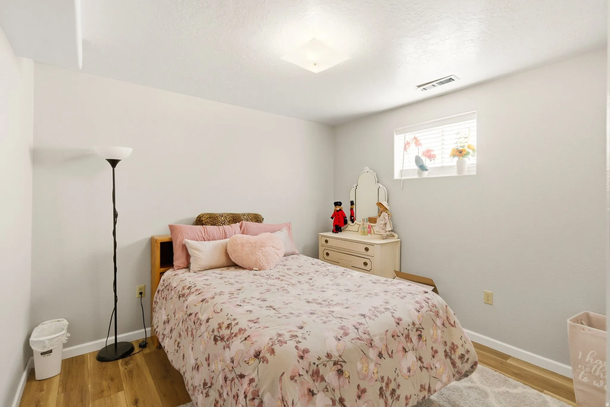 Bedroom with light wood-style flooring and a textured ceiling