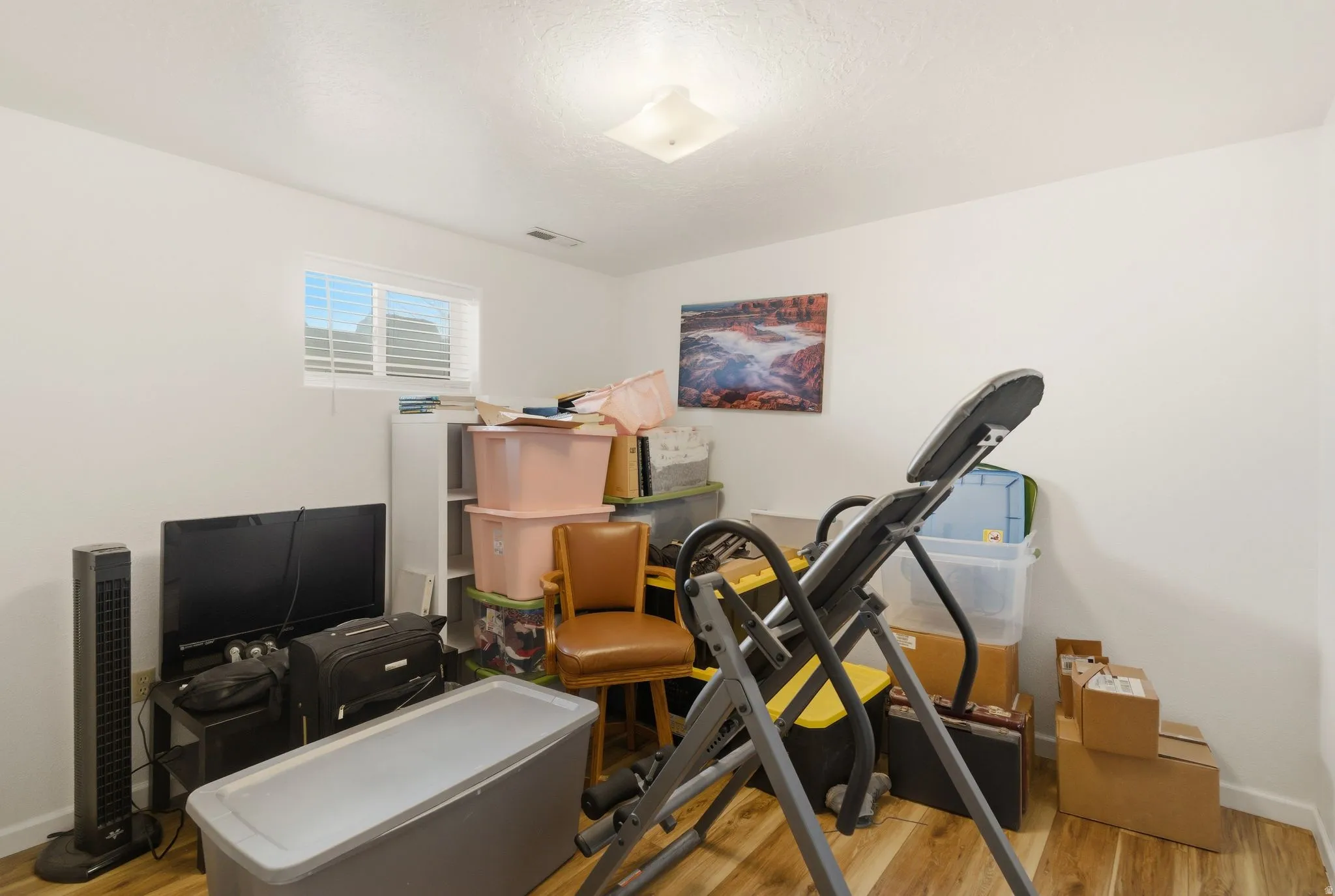 Exercise room featuring baseboards and light wood-style flooring