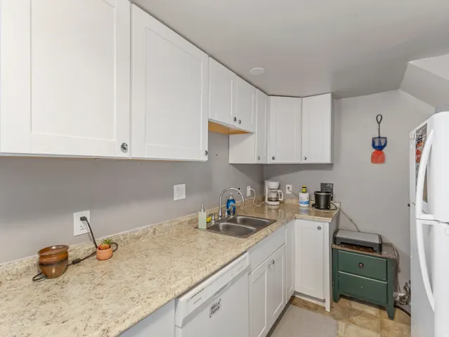 Kitchen featuring white cabinets and white appliances