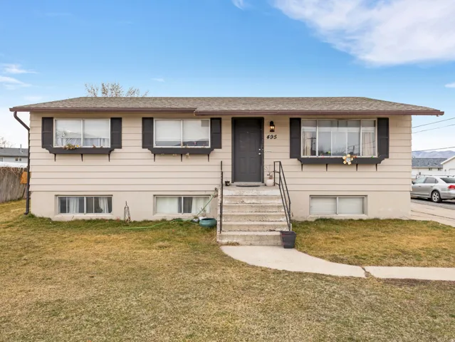 Split foyer home featuring a front lawn, roof with shingles.
