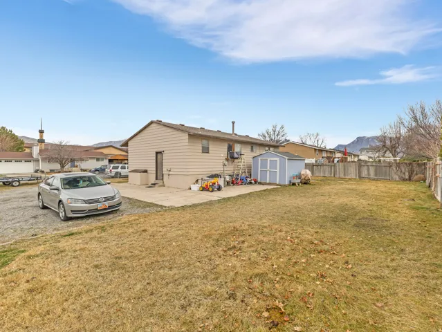 Back of house with a patio area, a storage unit, and a fenced backyard
