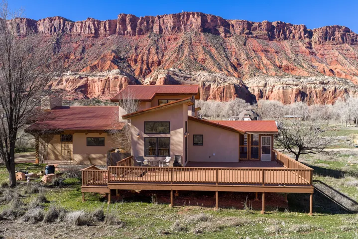 East side of home with view of red rock cliffs in background