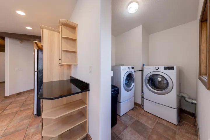 Laundry area featuring washing machine and dryer and baseboards