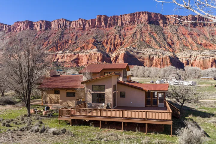 East side of home with view of red rock cliffs in background