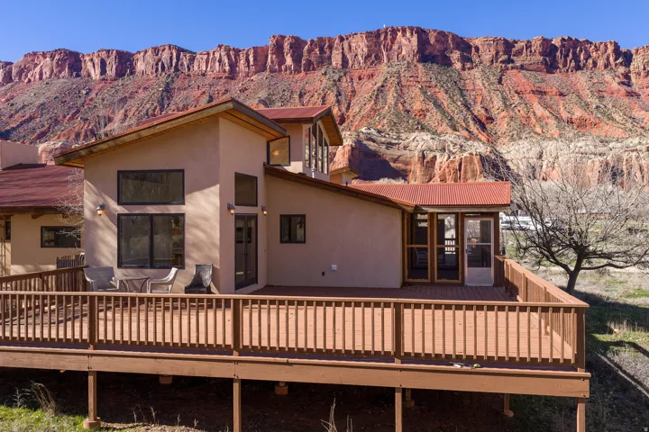 Rear view of home, large deck with two entries.  Porcupine Rim in background