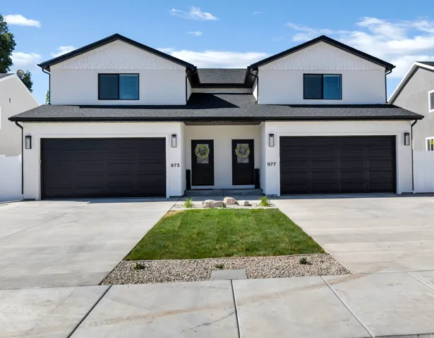 Modern farmhouse style home with an attached garage, a shingled roof, concrete driveway, and stucco siding