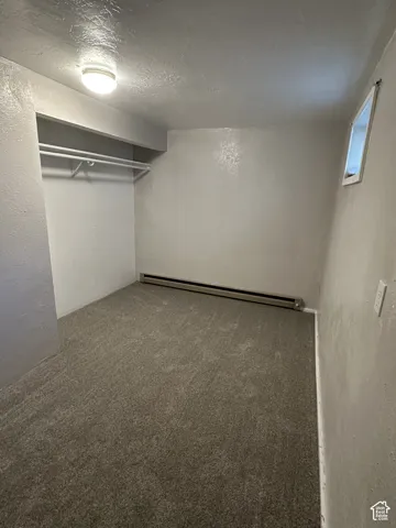 New Carpet, Basement Bedroom 4 Recessed closet with integrated hanging rod, wall-to-wall carpeting, and baseboard heating unit