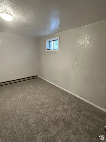 New Carpet, Basement Bedroom 4 Wall-to-wall carpeting with baseboard trim, an egress window, and ceiling-mounted lighting