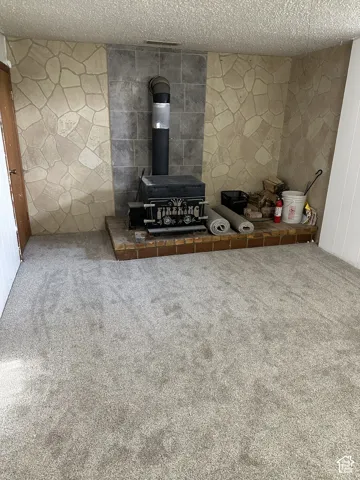 Freestanding wood-burning stove with a brick hearth and stone-look wall surround