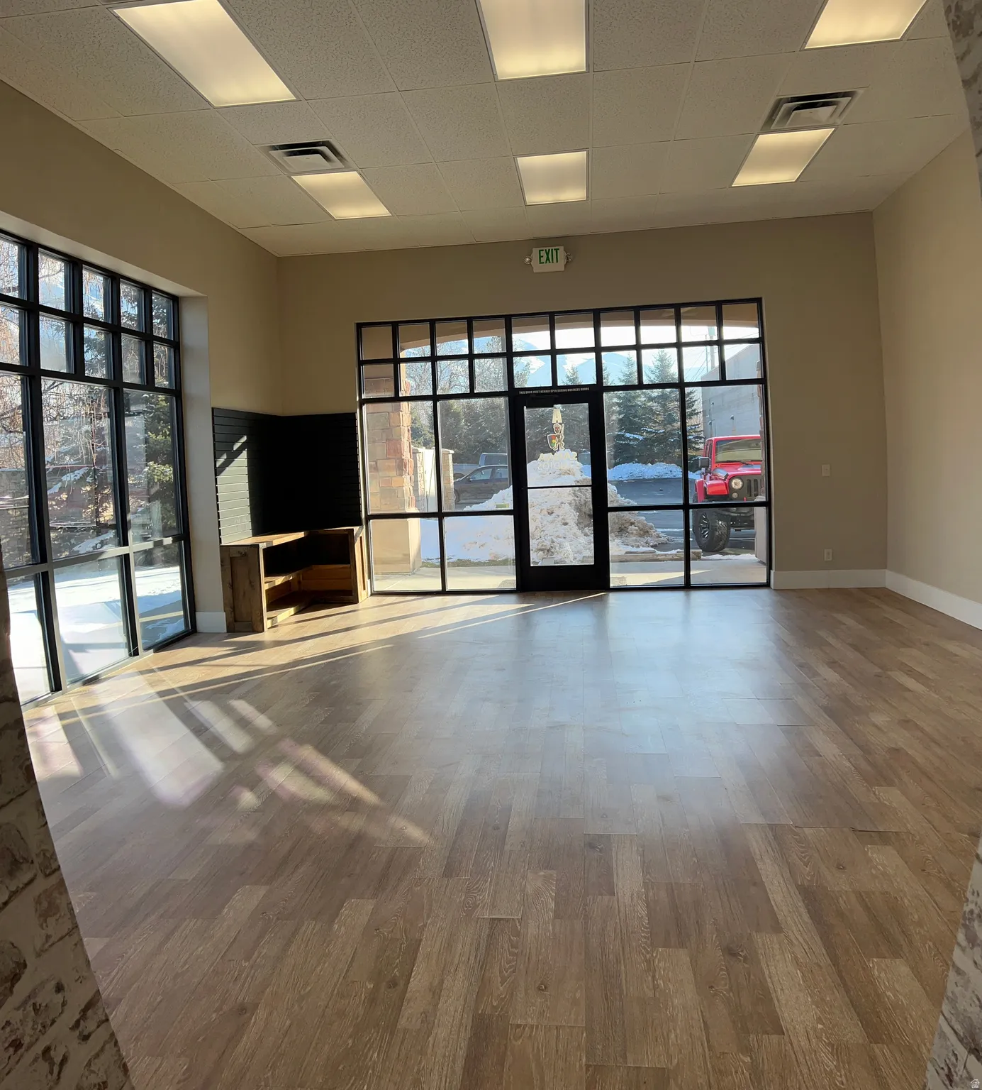 Empty room with a drop ceiling and wood finished floors