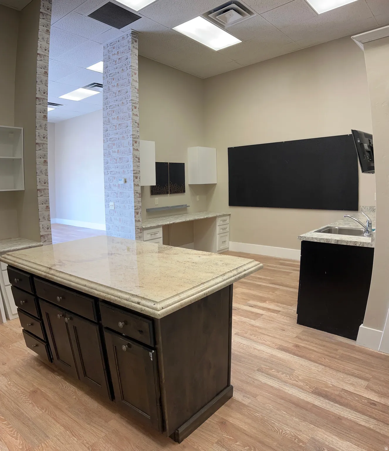 Kitchen with a kitchen island, light stone counters, and dual tone cabinets