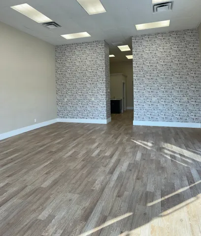 Spare room featuring wood finished floors and a paneled ceiling