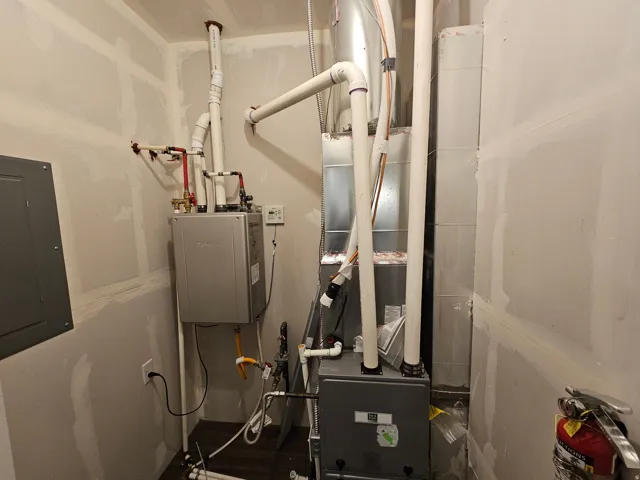 Utilities featuring electric panel, heating unit, and water heater