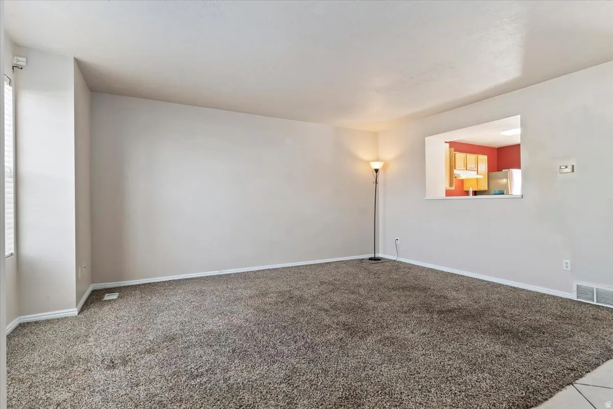 Carpeted empty room with baseboards