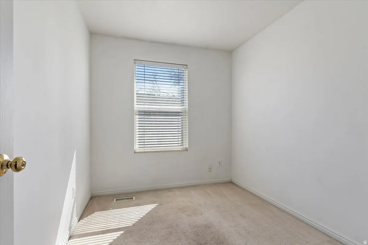 Unfurnished room with light carpet and baseboards