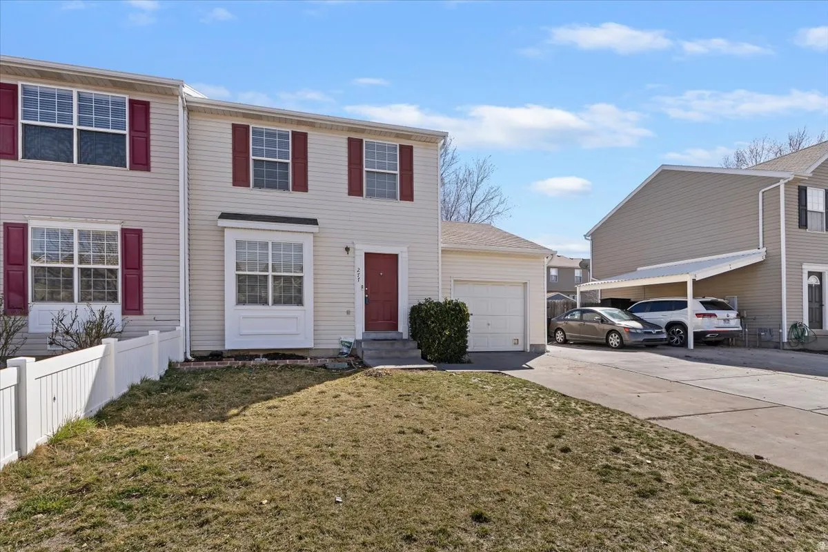 Colonial inspired home featuring driveway, a front yard, and an attached garage