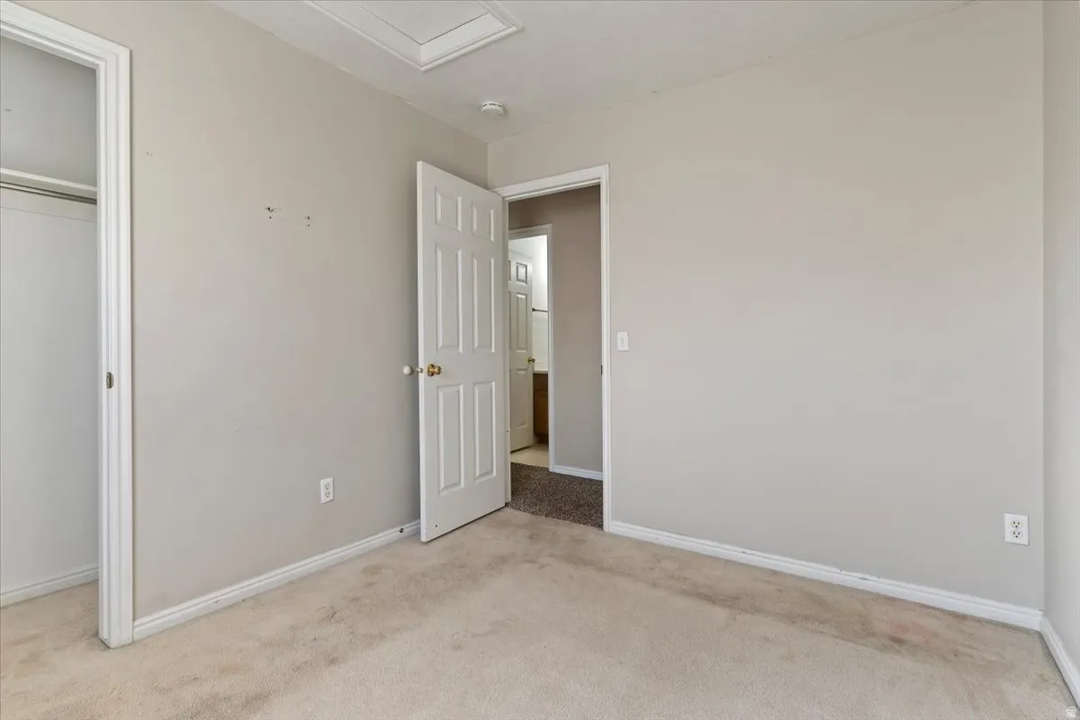 Unfurnished bedroom featuring light colored carpet and a closet
