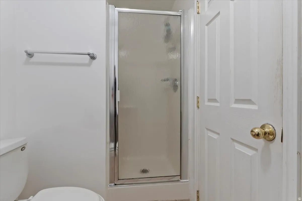 Bathroom featuring a shower stall and toilet