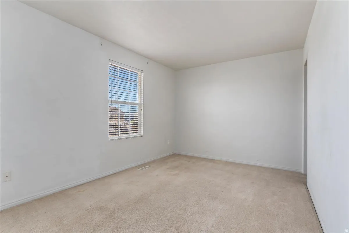 Spare room featuring carpet flooring and baseboards