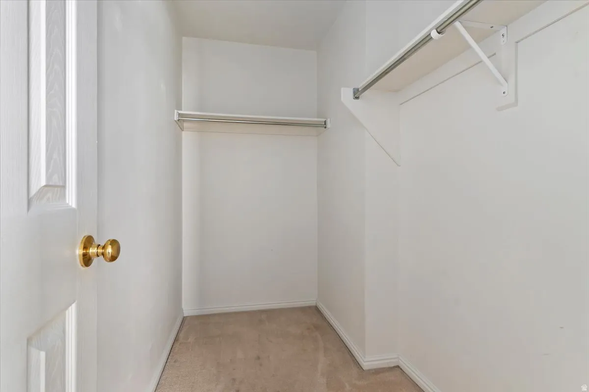 Walk in closet featuring light carpet