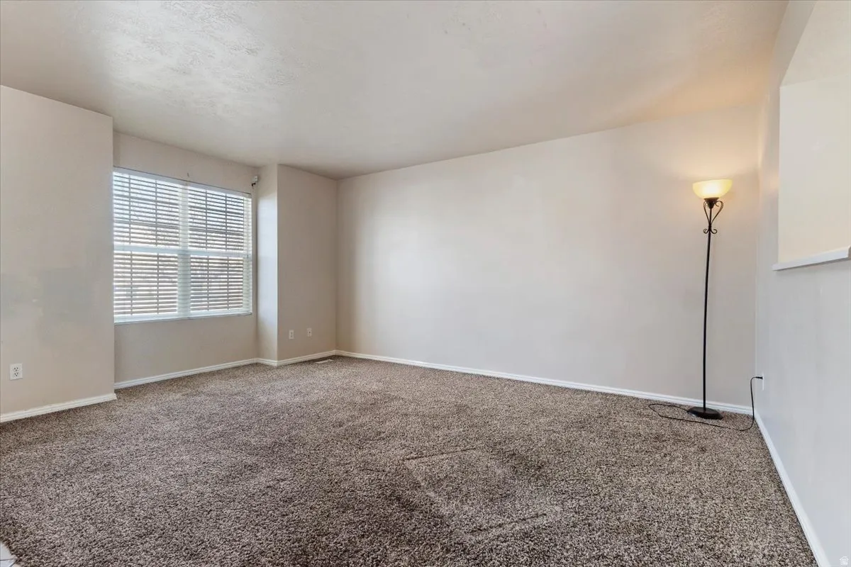 Unfurnished room with baseboards and carpet