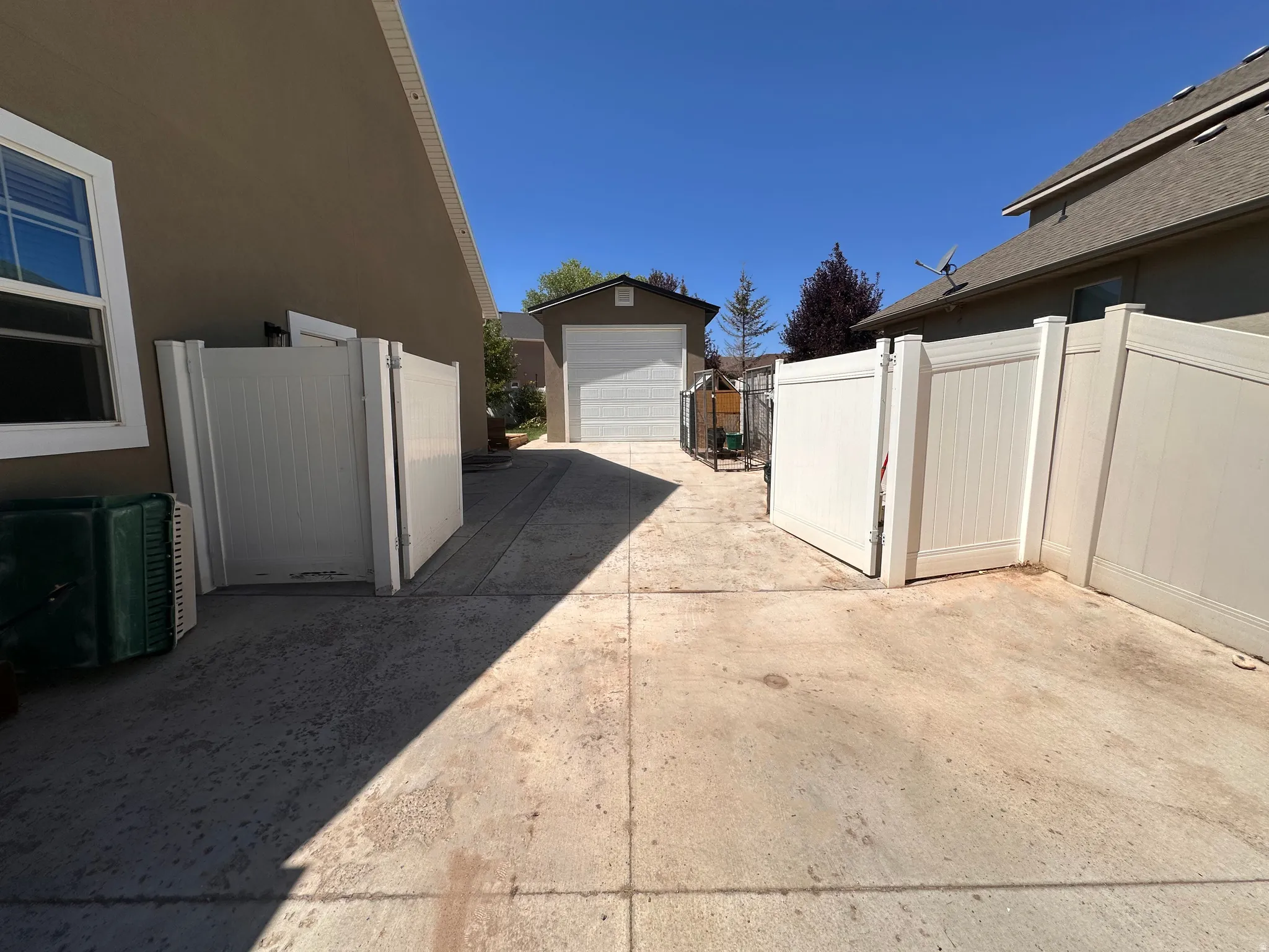 View of side of home with a garage, an outbuilding, and driveway