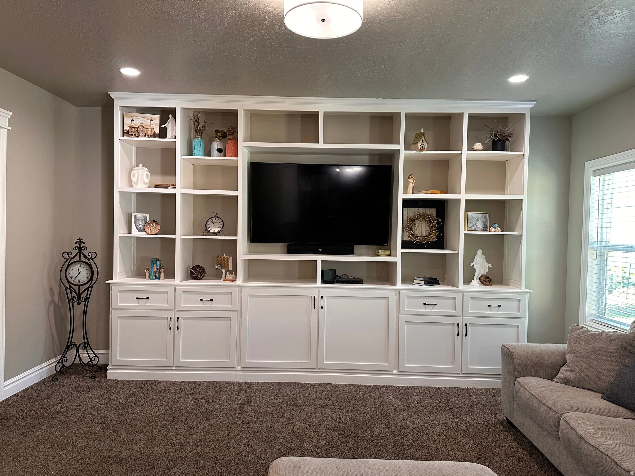 Living room featuring dark carpet, recessed lighting, and a textured ceiling