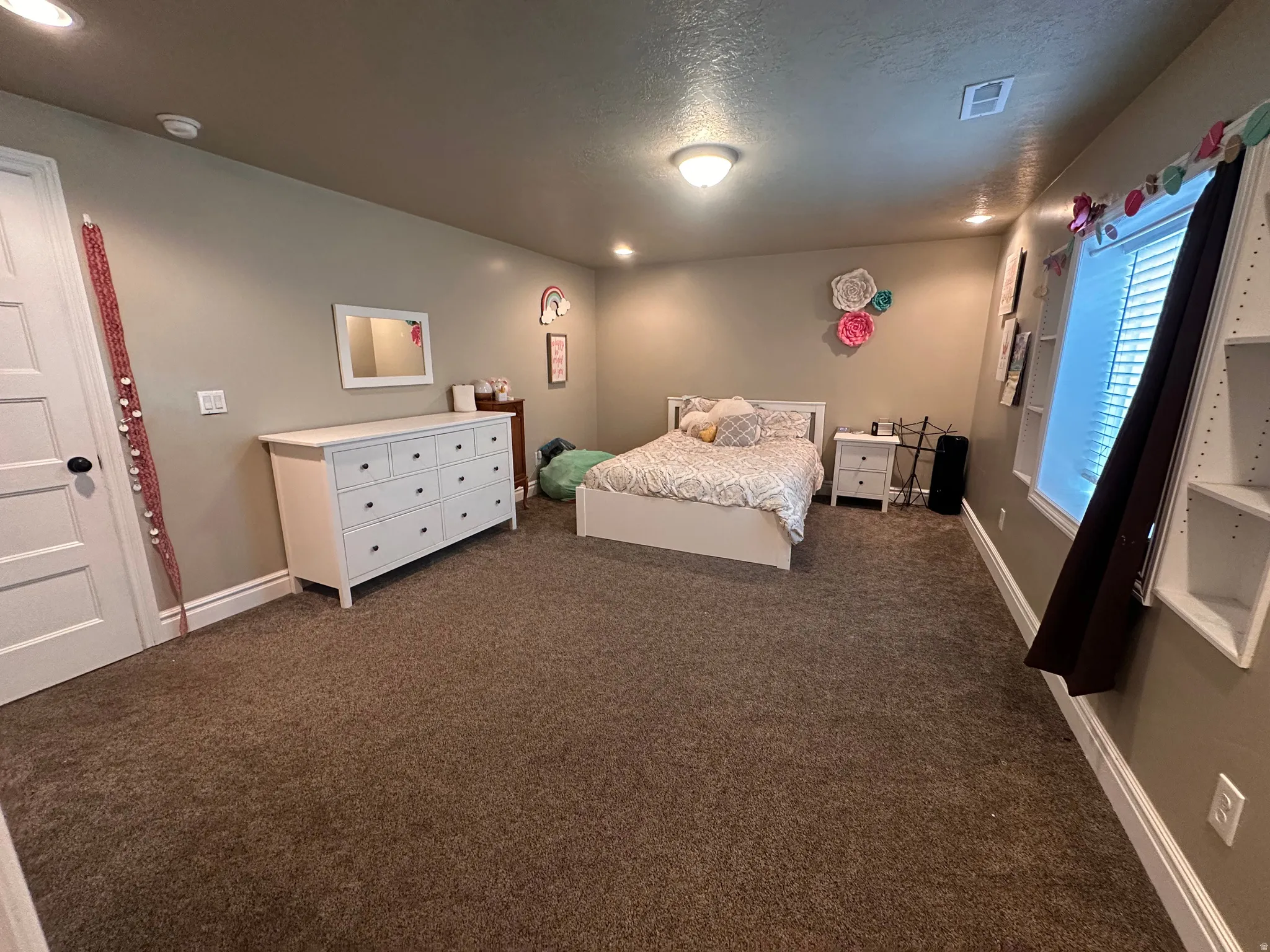 Bedroom featuring dark carpet and a textured ceiling