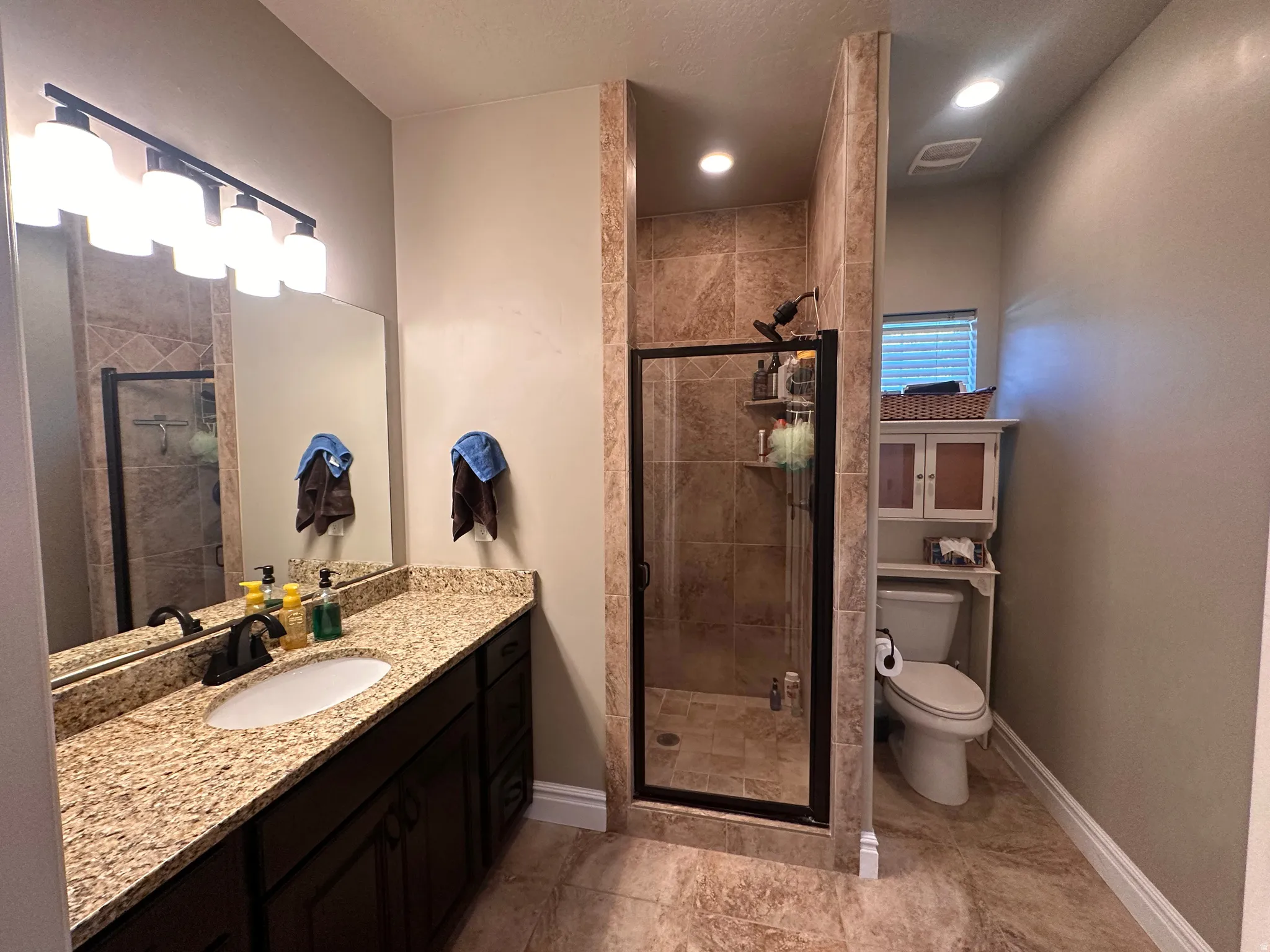 Full bathroom featuring a stall shower and vanity