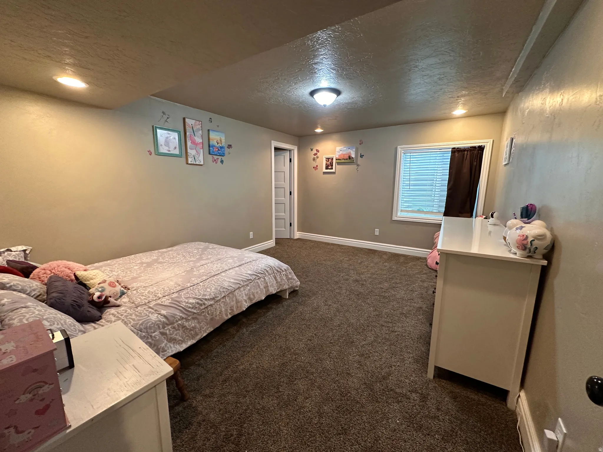 Bedroom featuring a textured ceiling and dark colored carpet
