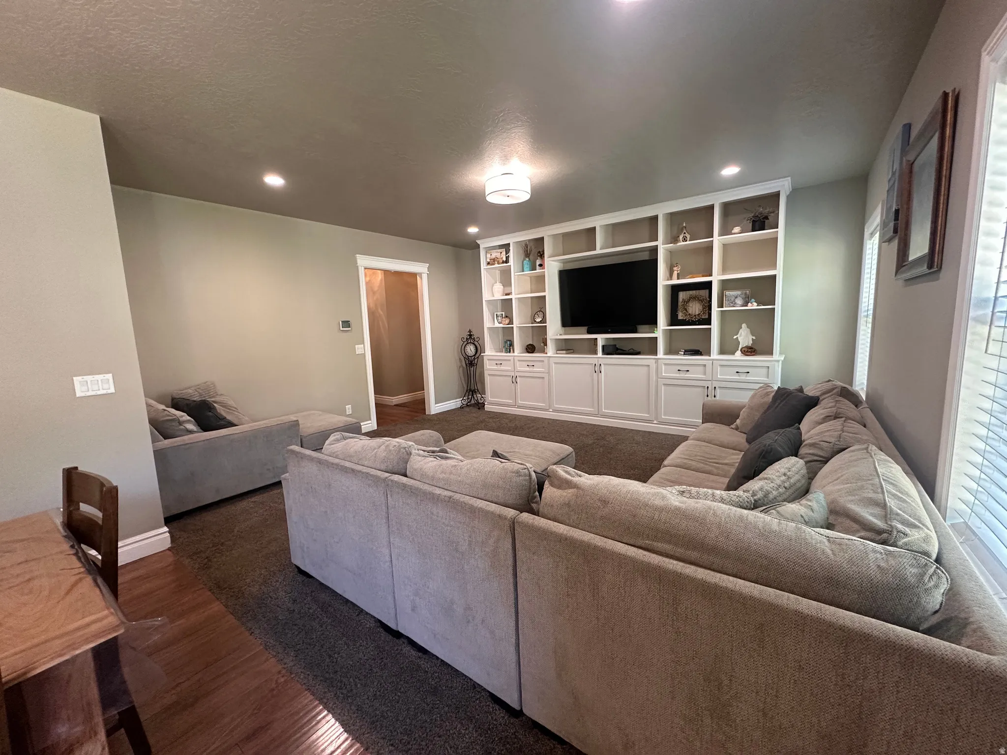 Living area with dark wood-style floors and recessed lighting
