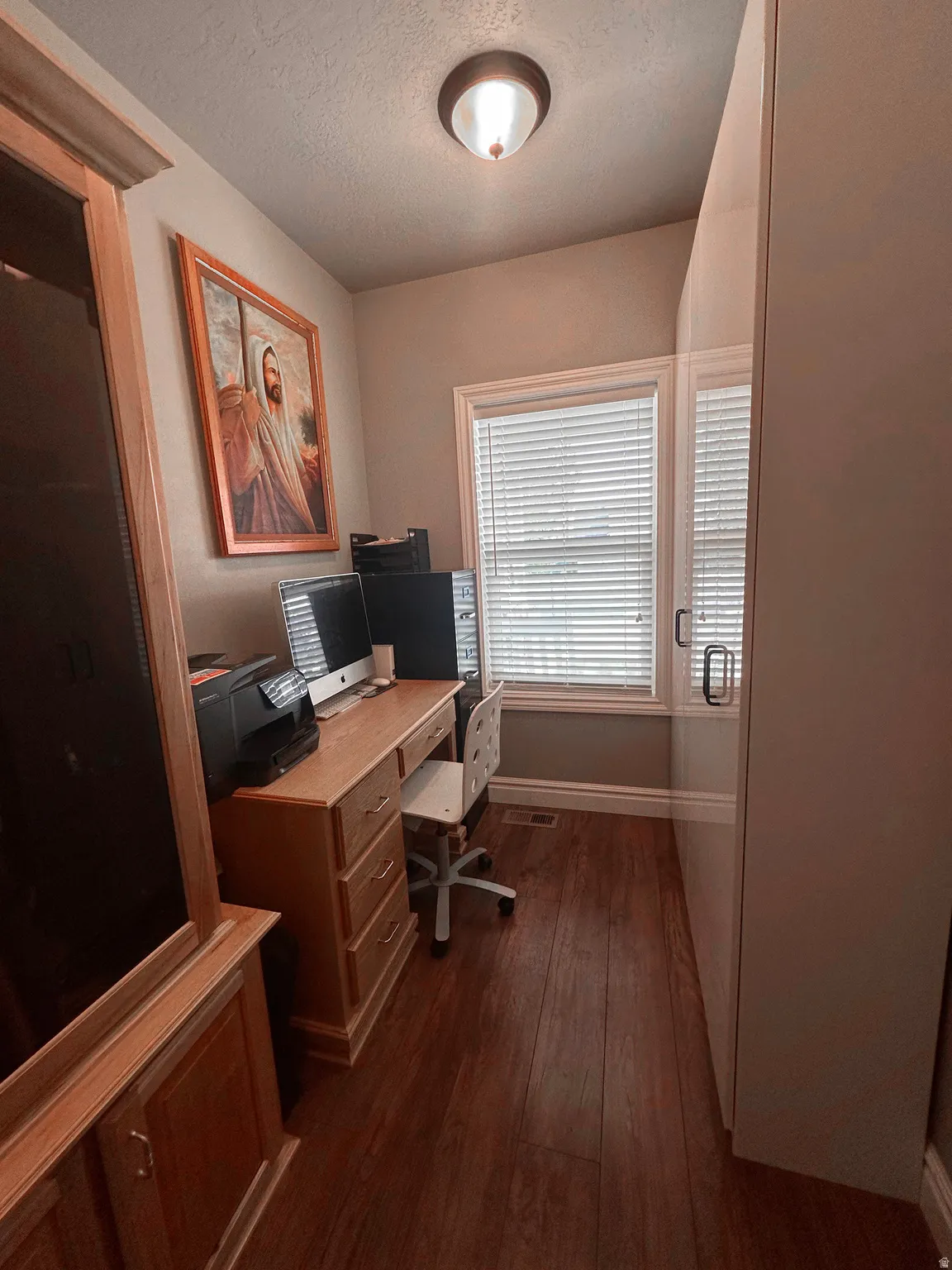 Office featuring dark wood finished floors and a textured ceiling
