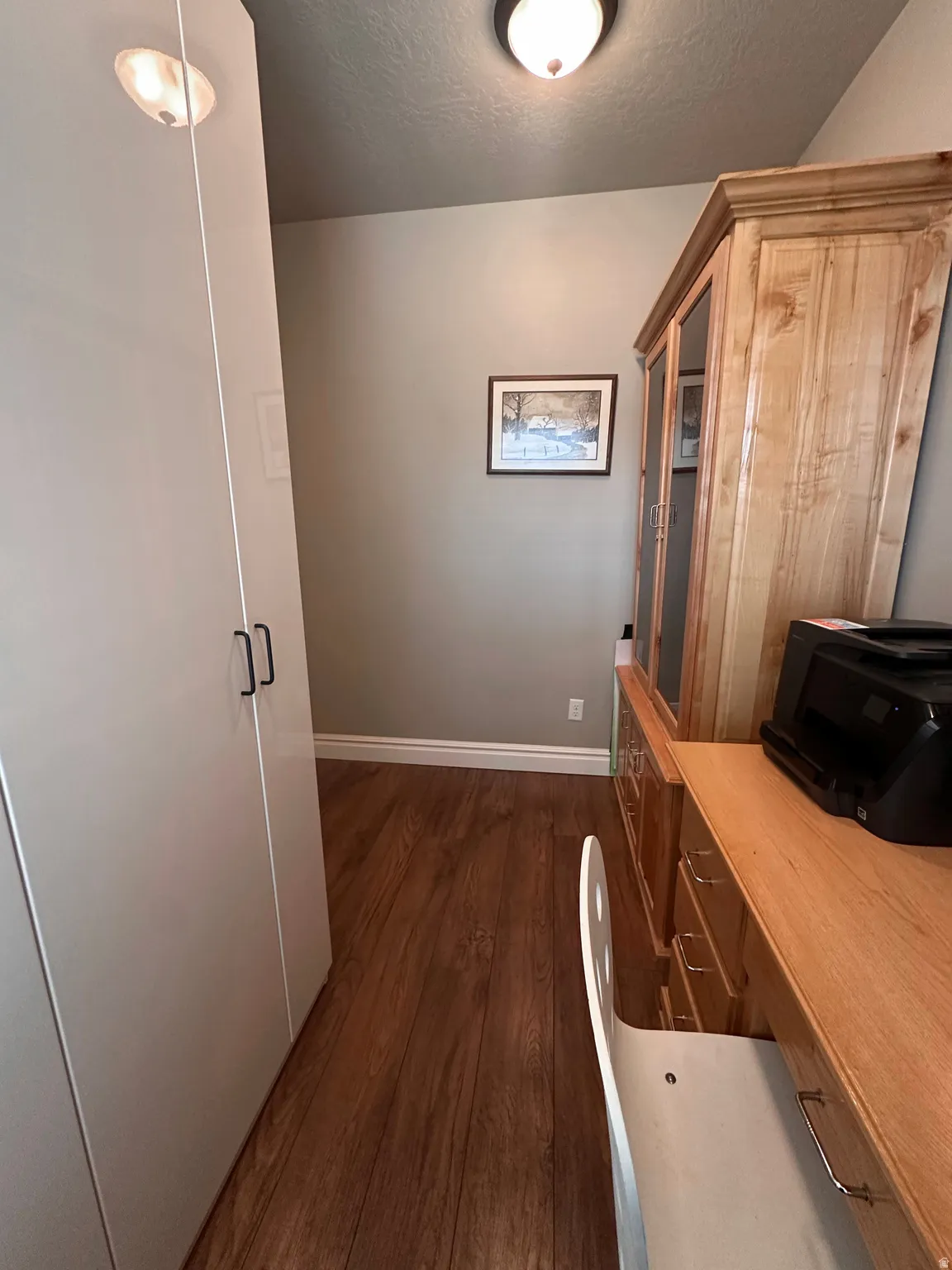 Office area featuring dark wood finished floors and a textured ceiling