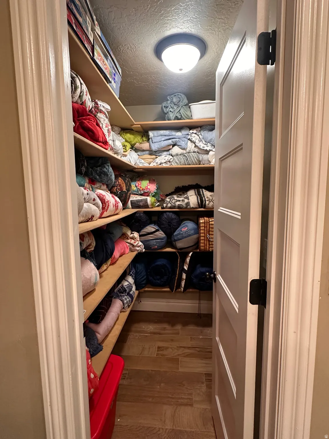 Walk in closet with dark wood-type flooring