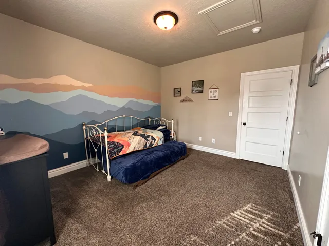 Bedroom with dark carpet and a textured ceiling