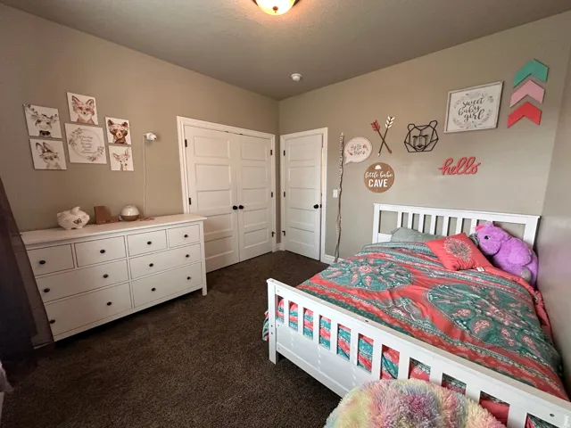 Bedroom with dark carpet and a closet