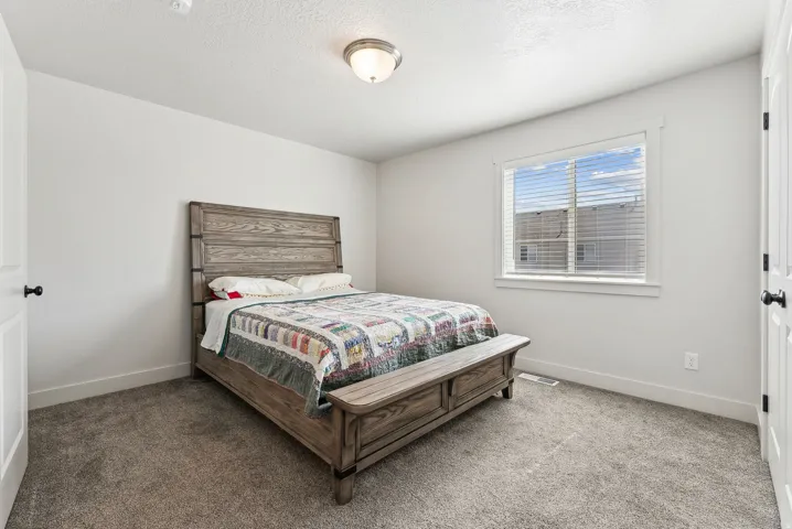 Bedroom with light carpet and a textured ceiling