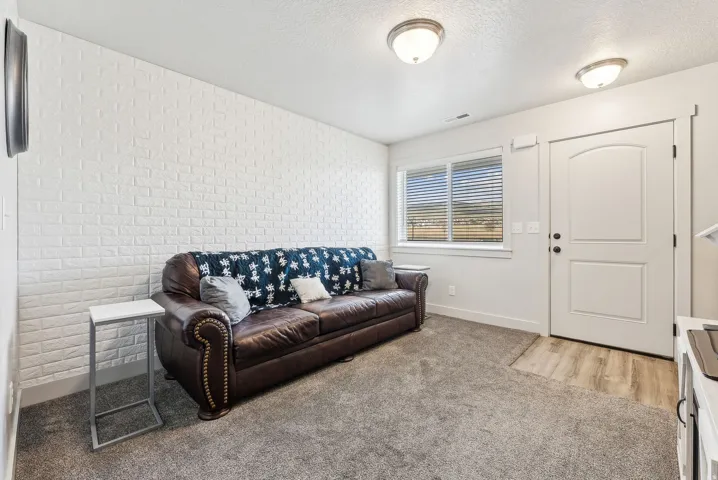 Carpeted living room with a textured ceiling and an accent wall